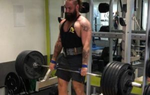 man lifting heavy weights in a gym